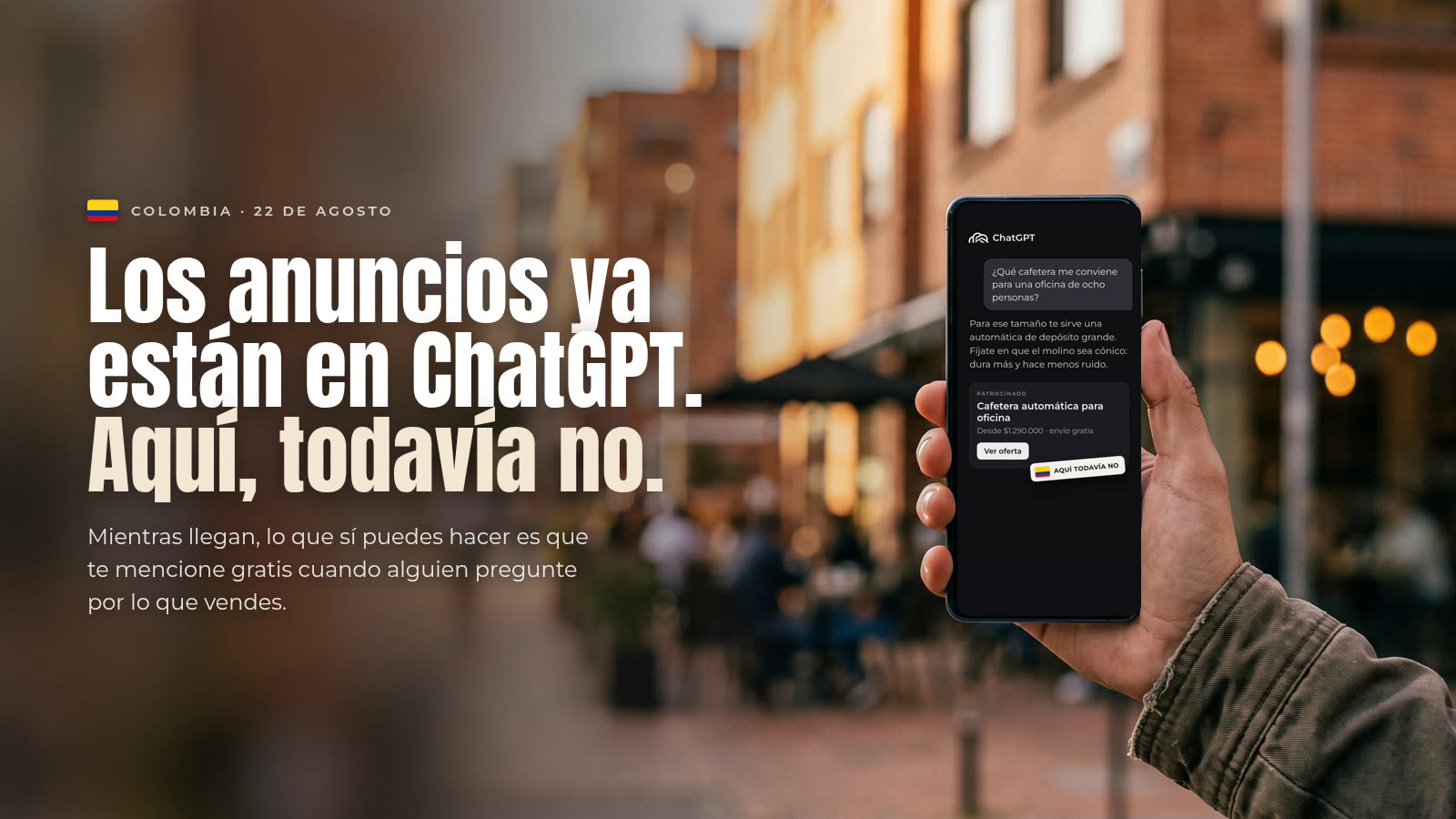 Mano sosteniendo un celular en una calle de Bogotá con una conversación de ChatGPT que muestra un anuncio patrocinado y el sello con la bandera de Colombia "Aquí todavía no", junto al titular "Los anu
