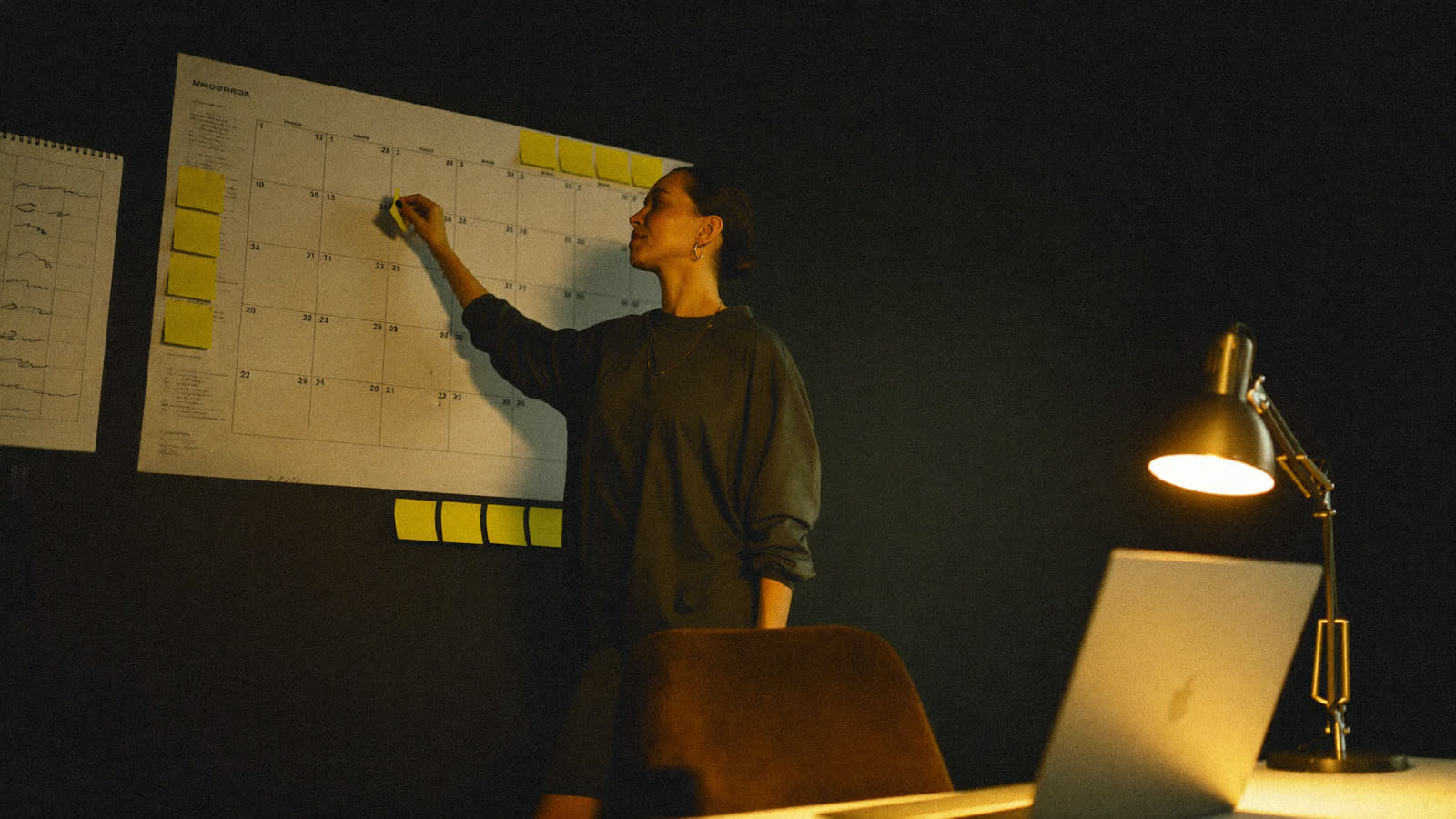 Estratega organizando un calendario de contenido con notas adhesivas en la pared